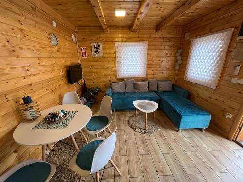 a living room with a couch and tables and chairs at Brvnare MADERA Banja Ždrelo in Ždrelo