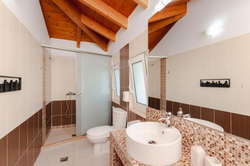 a bathroom with a sink and a toilet at Renthub Villas at Kolympia in Kolimbia