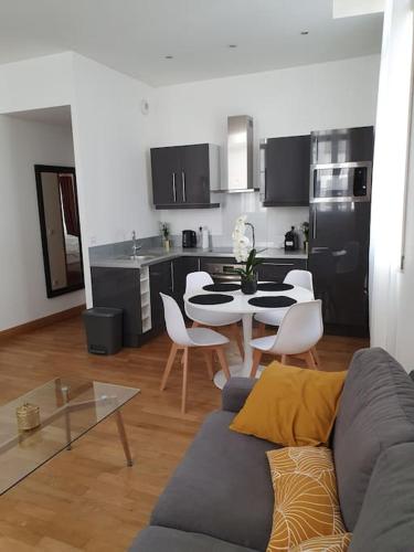 a living room with a couch and a table in a kitchen at L'APPART'JEANNIN HYPER CENTRE in Dijon