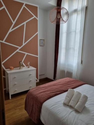 a bedroom with a bed with two pillows and a window at L'APPART'JEANNIN HYPER CENTRE in Dijon