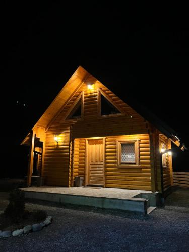 a cabin with lights on the side of it at night at Brvnare MADERA Banja Ždrelo in Ždrelo
