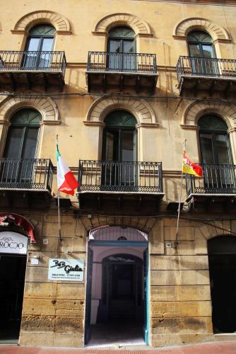 a building with two flags in front of it at B&B Giulia Caltanissetta in Caltanissetta