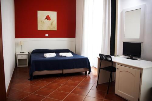 a bedroom with a bed and a desk with a computer at B&B Giulia Caltanissetta in Caltanissetta