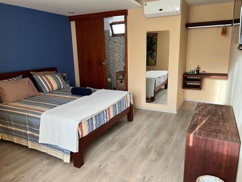 a bedroom with a large bed and a bathroom at Orietta Residencial in Mindelo