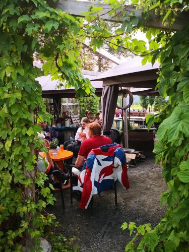 a group of people sitting at tables under a canopy at Lensmannsgården in Namdalseid