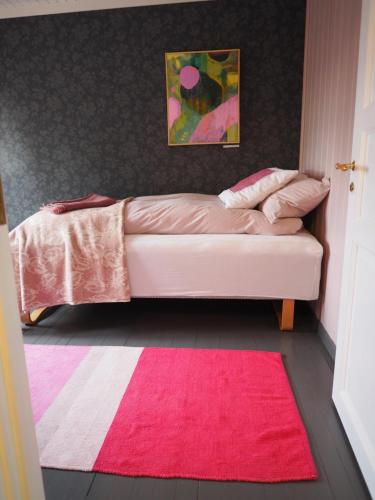 a bedroom with a couch with a red rug at Lensmannsgården in Namdalseid