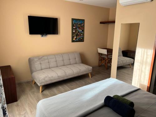 a living room with a couch and a flat screen tv at Orietta Residencial in Mindelo