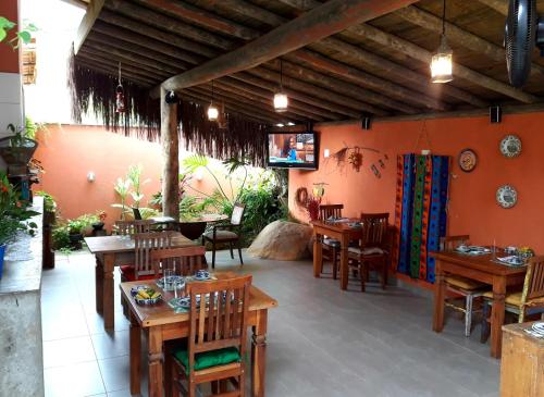 a restaurant with wooden tables and chairs in a room at Suítes Cambucá in Ilhabela