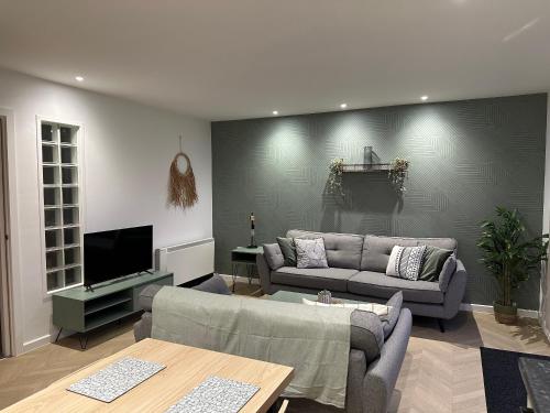 a living room with a couch and a tv at Beach View Flat on Coastal Path in Llanelli