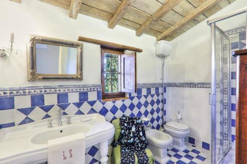 baño azul y blanco con lavabo y aseo en Villa Tramonto, en Querce