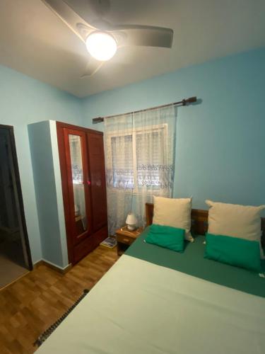 Un dormitorio con una cama grande con almohadas verdes y blancas en Résidence Beyt Salama - T1bis ou T4, en Antsiranana