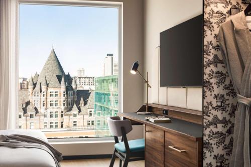 a bedroom with a desk and a large window at Hyatt Centric Montreal in Montréal