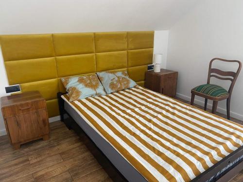 1 dormitorio con 1 cama grande y cabecero amarillo en Beskid Family&Chill, en Tenczyn