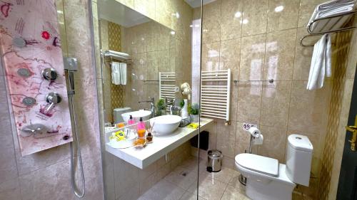 a bathroom with a toilet and two sinks and a shower at Angel's Home Hotel - Angel Group Hotels in Istanbul