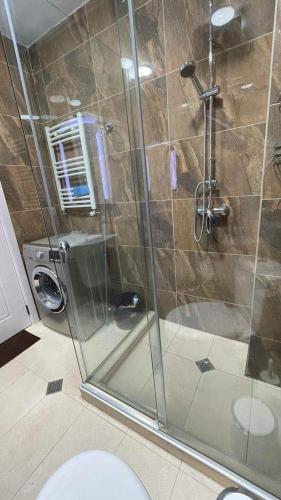 a bathroom with a glass shower with a toilet at Didveli Residence Studio Apartment in Bakuriani