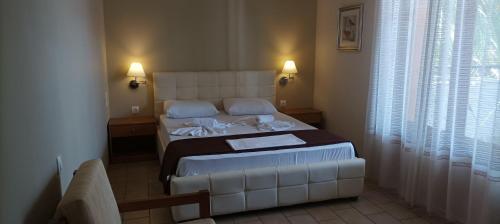 a bedroom with a large white bed with two pillows at Vanta Hotel in Limenas