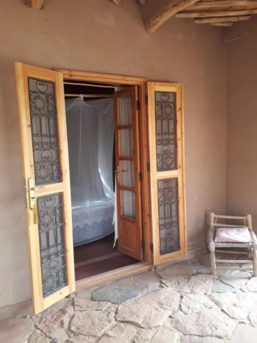 Puerta abierta de una habitación con cama en Dar Paru, en Mhamid