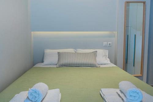 1 dormitorio con 1 cama con 2 toallas y espejo en Nikkis Flat - Kolonaki Square en Athens