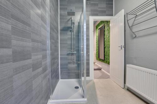a bathroom with a shower with a glass door at Stylish base on Abbeydale Road in Sheffield