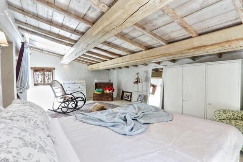 1 dormitorio con 1 cama grande y 1 silla en Villa Tramonto, en Querce