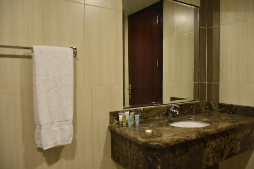 a bathroom with a sink and a mirror at Al Jury Serviced Apartments in Al Khobar