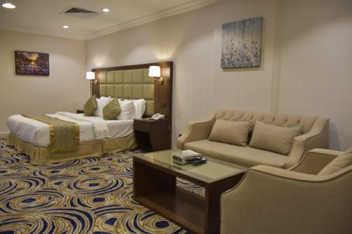 a hotel room with a bed and a couch at Al Jury Serviced Apartments in Al Khobar