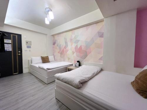 Zimmer mit 2 Betten und einer Wand in der Unterkunft FengChia FUN House in Taichung