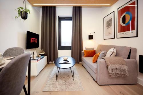 a living room with a couch and a table at Luxury new built split-level flat with rooftop gardens access in Manchester