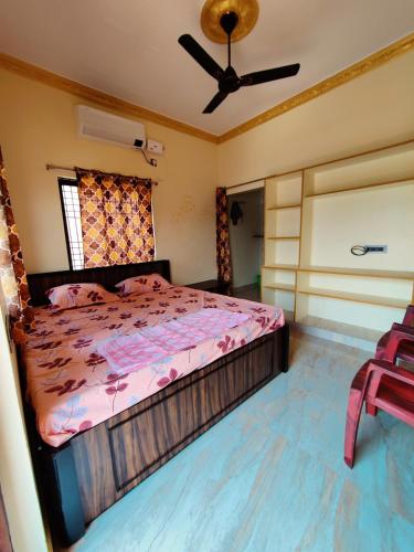 a bedroom with a bed and a ceiling fan at Balaji Homestay in Hampi