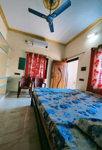 a bedroom with a bed and a ceiling fan at Balaji Homestay in Hampi