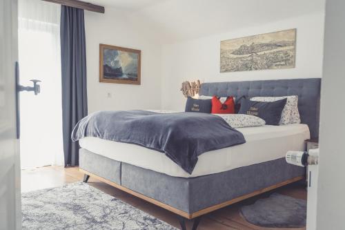 een slaapkamer met een bed met een blauw hoofdeinde bij Haus Victoria in Sankt Gilgen