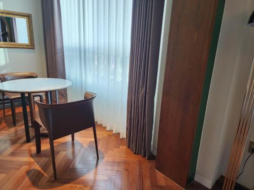 LE SEOUL HOTEL في سول: طاولة وكرسي في غرفة مع نافذة