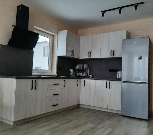 a kitchen with white cabinets and a refrigerator at У Мирослави in Pilipets