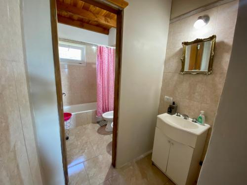 uma casa de banho com um lavatório, um WC e um espelho. em Lake em San Carlos de Bariloche