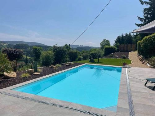 uma grande piscina azul num quintal em Gezellige luxe caravan met zwembad in zuid- Bourgogne em Anglure-sous-Dun