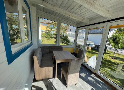 a screened porch with a table and chairs and windows at Ostseehaus am Wasser in Barth