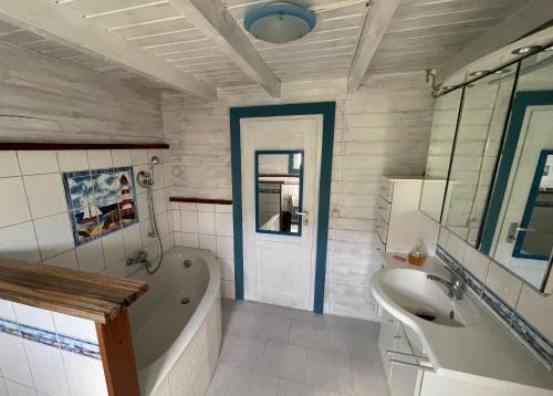 a bathroom with a bath tub and a sink at Ostseehaus am Wasser in Barth
