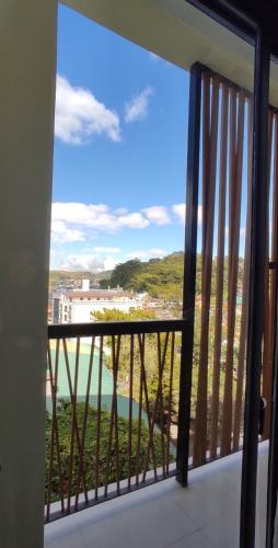 um quarto com uma varanda com vista para o oceano em Olive Town Center and Hotel em Baguio