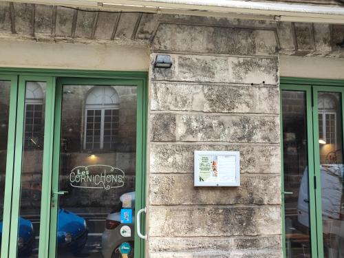 a stone building with green doors and a sign on it at Studio en Duplex-Aircon-Terrasse-Parking-Calme in Bordeaux