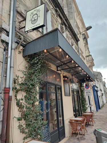 a restaurant with a sign on the side of a building at Studio en Duplex-Aircon-Terrasse-Parking-Calme in Bordeaux