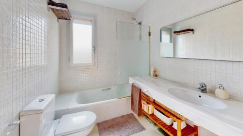 a bathroom with a toilet and a sink and a mirror at Villa Sol in L'Ampolla