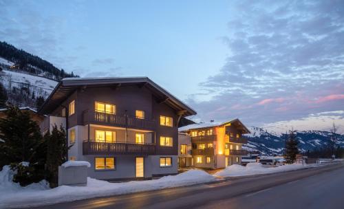 a large building with lights on in the snow at Auhof - Apartments Bad Gastein in Bad Gastein