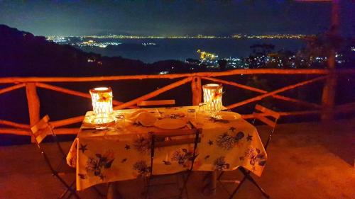 a table with plates and glasses on it at night at La Casetta nel Bosco in Ischia