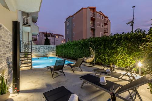 a patio with chairs and a swimming pool at Holiday apartments Stobrec in Split