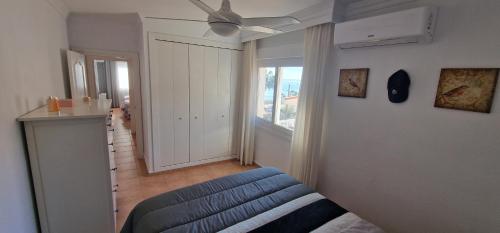 a living room with a blue couch and a ceiling fan at PLAYA RINCON De LA VICTORIA in Rincón de la Victoria