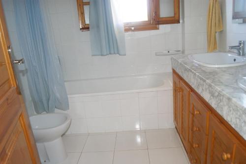 a bathroom with a toilet and a sink and a tub at Las Haciendas Marineu in Alcossebre