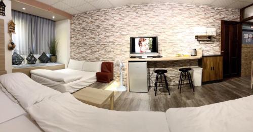 a living room with a white couch and a brick wall at Fengjia Gift Box Homestay in Taichung