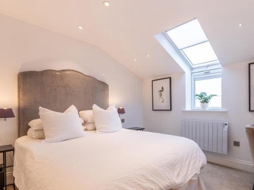 a bedroom with a large white bed with a skylight at 5 Clough Cottages in Clitheroe