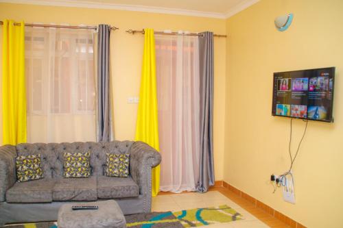 a living room with a couch and yellow curtains at GB Homes in Eldoret