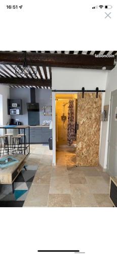 une chambre avec une porte et une cuisine avec une table dans l'établissement Studio de charme le Clos de l'Etang + place de parking, à LʼIsle-sur-la-Sorgue